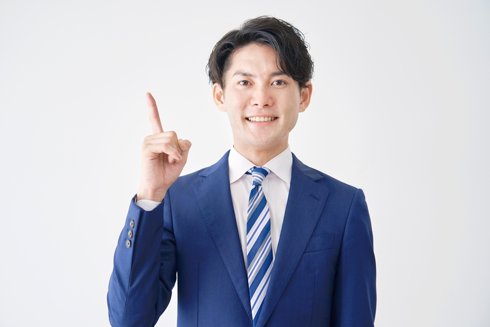 Asian,Businessman,Pointing,Side,In,White,Background